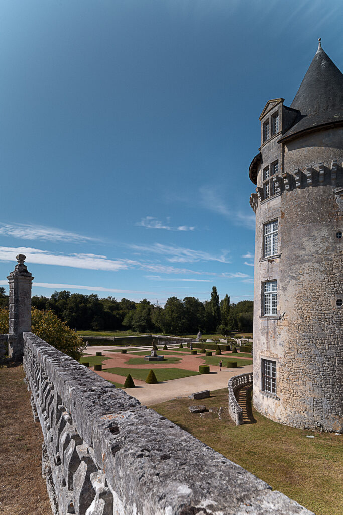 Photographie d'architecture historique. Les jardins du château de Laroche Courbon et son bassin en été, situé en Charentes-maritimes.